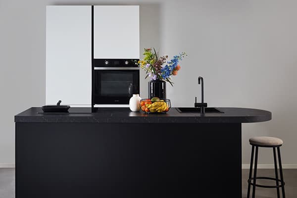 Zwarte-eilandkeuken-met-witte-hoge-kasten