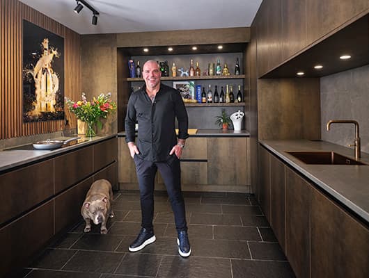 Donkere U-keuken met hout en bronzen fronten